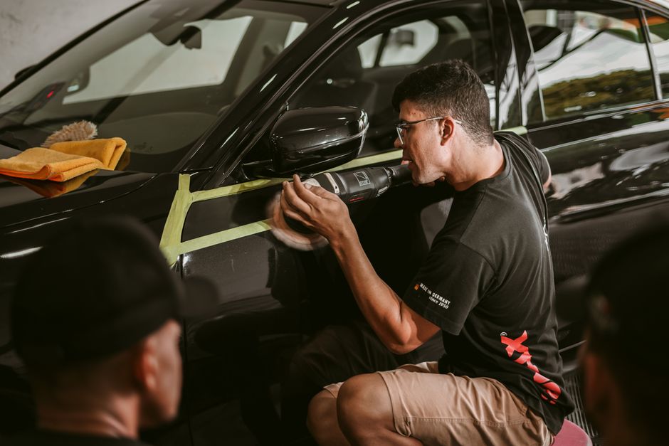 Auto detailer working meticulously on a vehicle